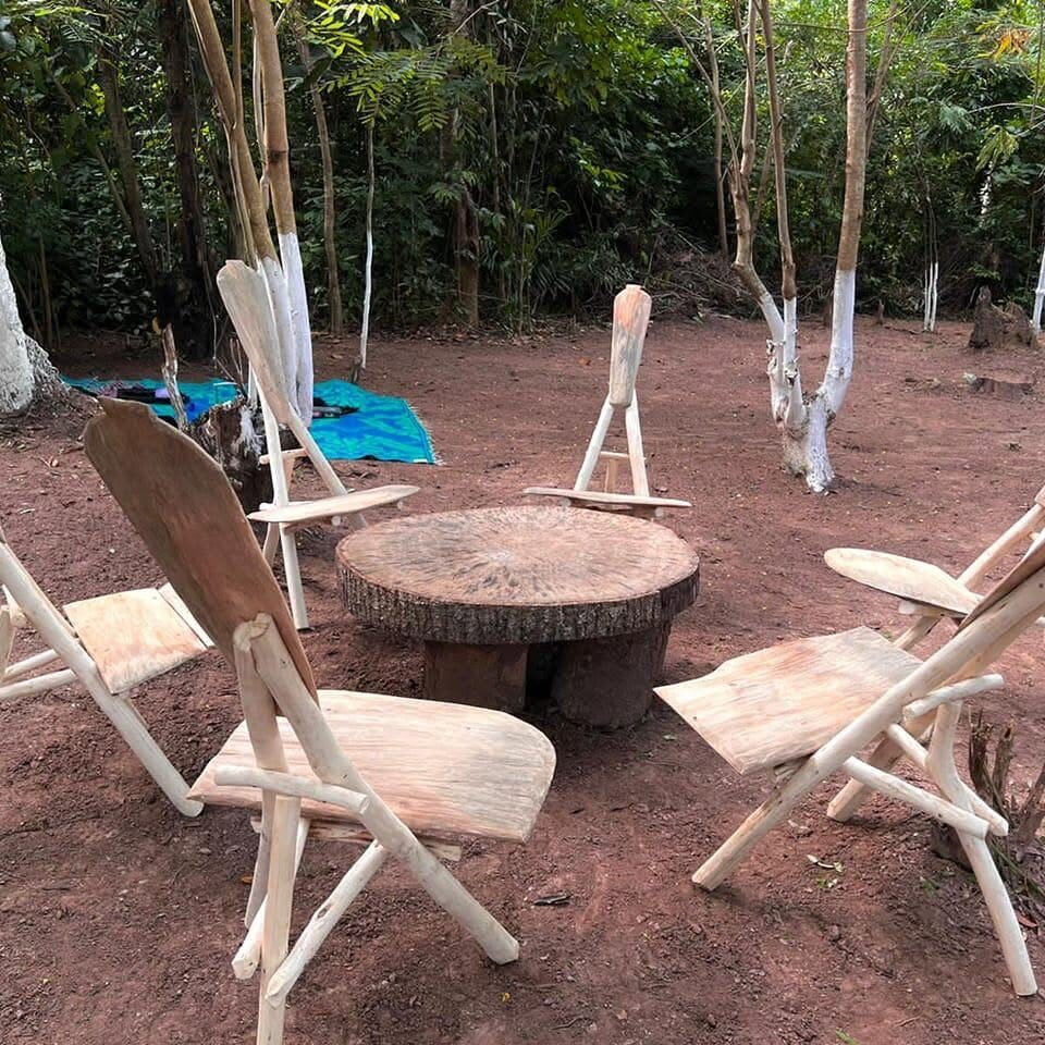 Fauteuils en bois autour d'une table basse dans un coin détente ombragé.